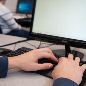 Student typing on a keyboard